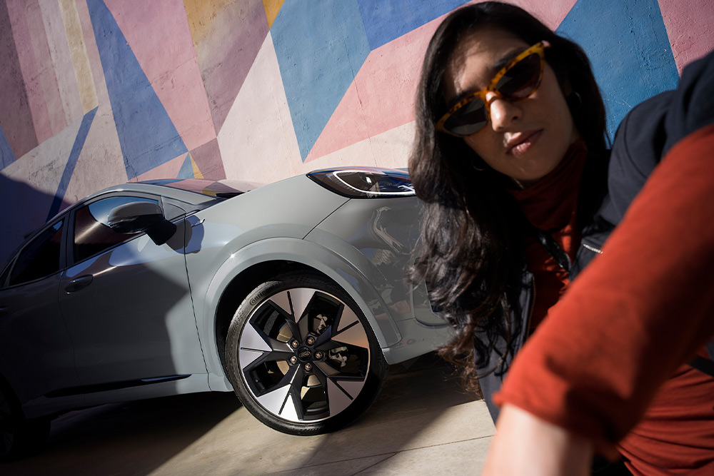 Une personne est assise à côté d’un Ford Puma Mild Hybrid. 