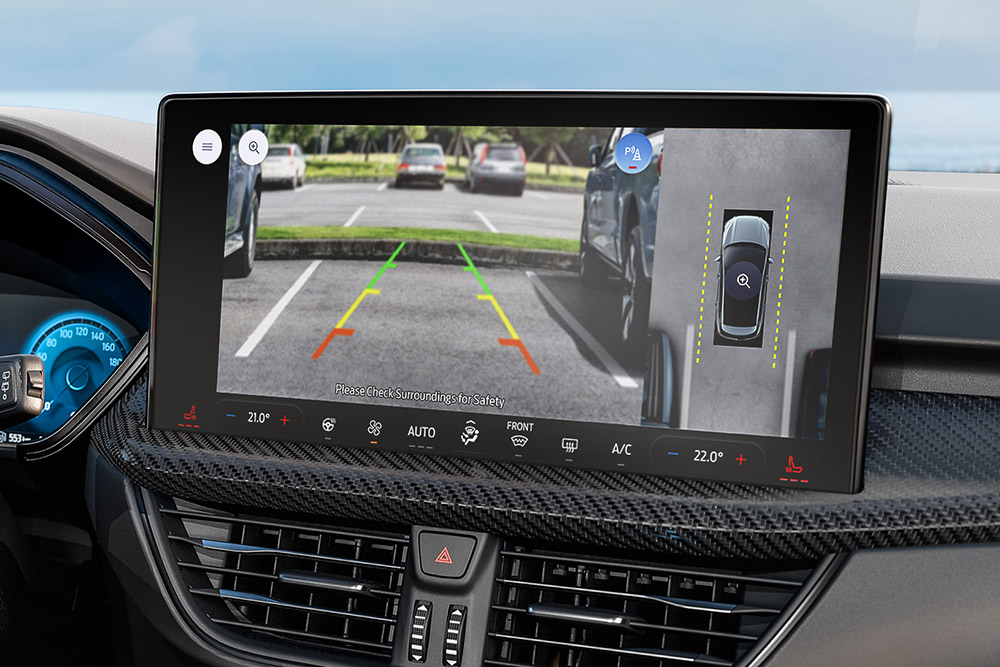 Gros plan du tableau de bord d'un Ford Kuga, avec un focus sur l'écran d'infodivertissement numérique affichant la caméra à 360 degrés.