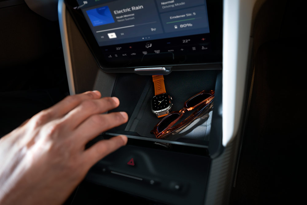 Une main dans le compartiment «My Private Locker» de la Ford Capri®. On y voit une montre et des lunettes de soleil.