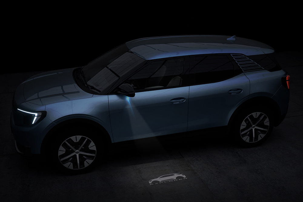 Vue latérale d'un Ford Explorer la nuit avec une projection de logo sur le sol