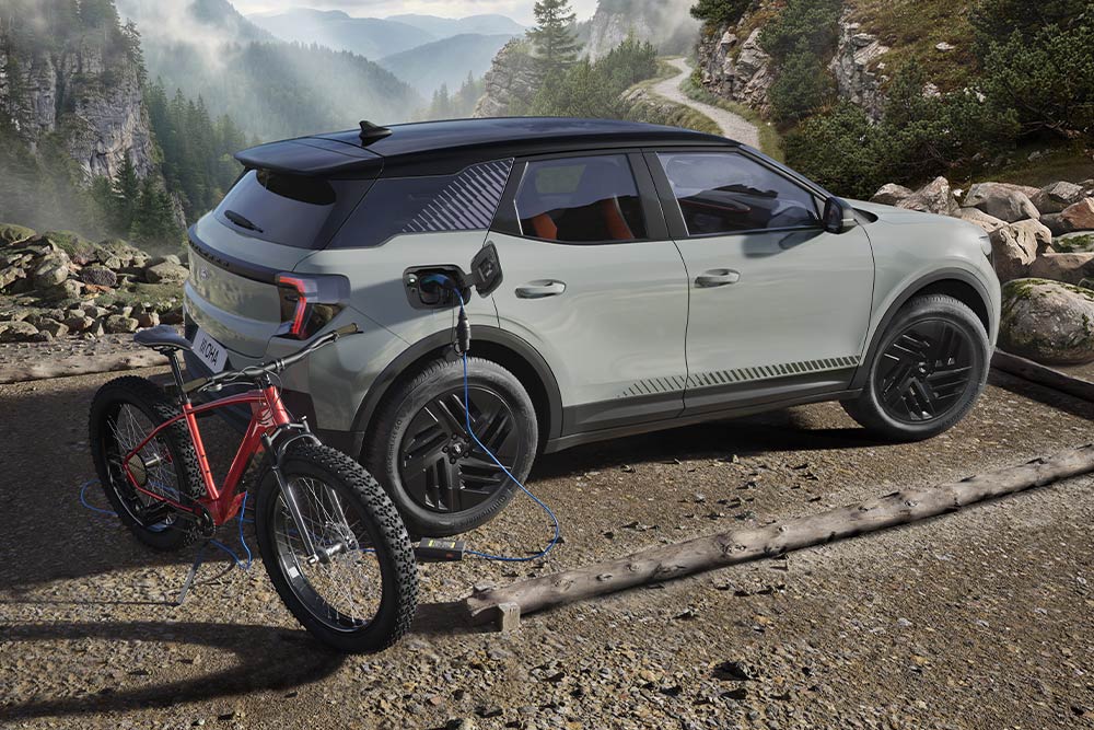 Un vélo électrique en charge depuis un Ford Explorer®, un paysage montagneux en arrière-plan.