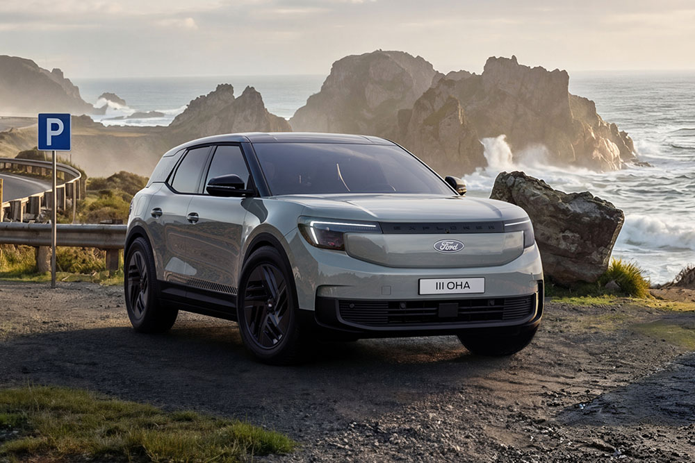 Un Ford Explorer® Collection argenté stationné le long d’une route bordant un rivage rocheux.