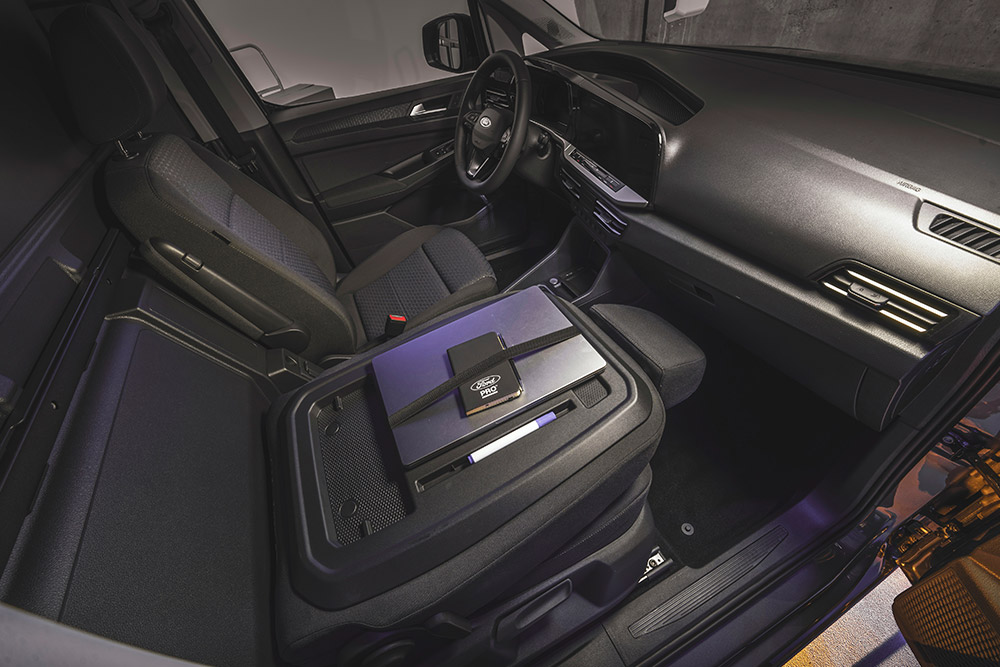 Intérieur du Ford Transit Connect  montrant le tableau de bord, les sièges, un ordinateur portable et un smartphone sur la console centrale.