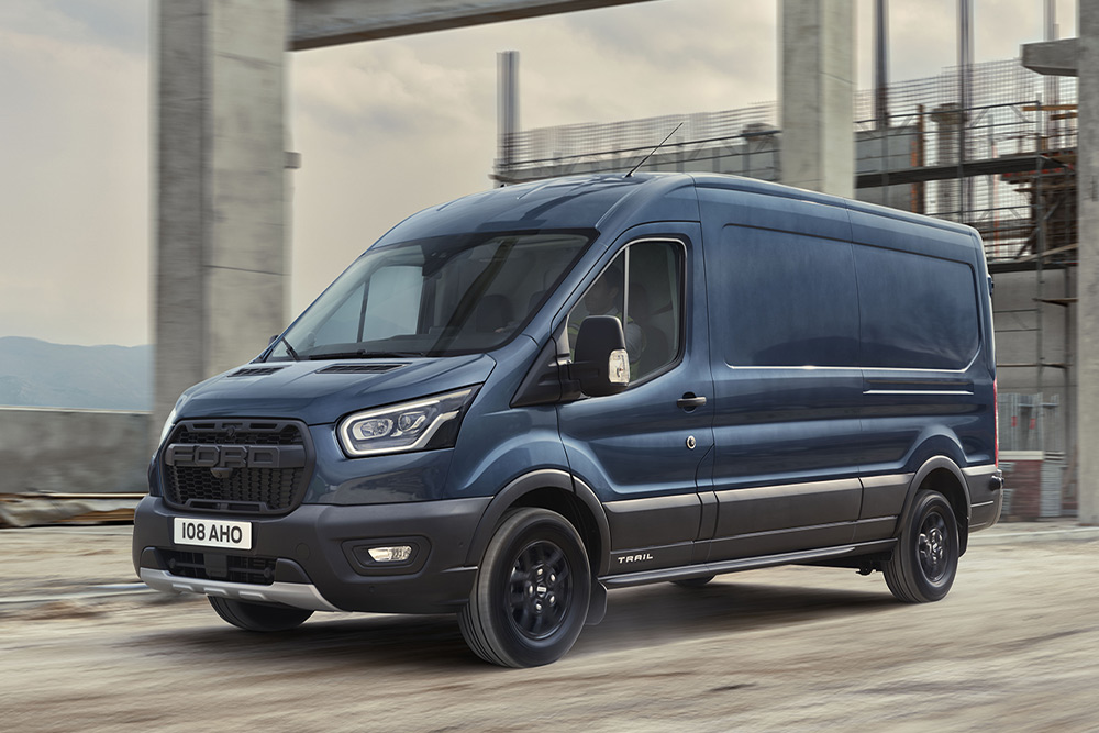 Ford Transit Fourgon Trail couleur bleue, vue de face aux trois quarts, roulant sur un chantier 