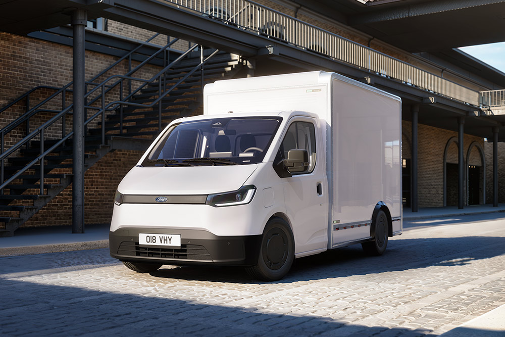 Ford Transit City® Châssis Cabine blanc garé devant un bâtiment en briques.