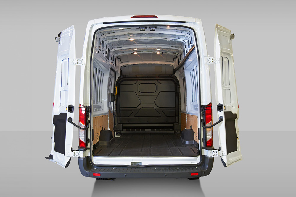 Vue arrière de l'intérieur d'une camionnette Ford Pro Transit blanche.