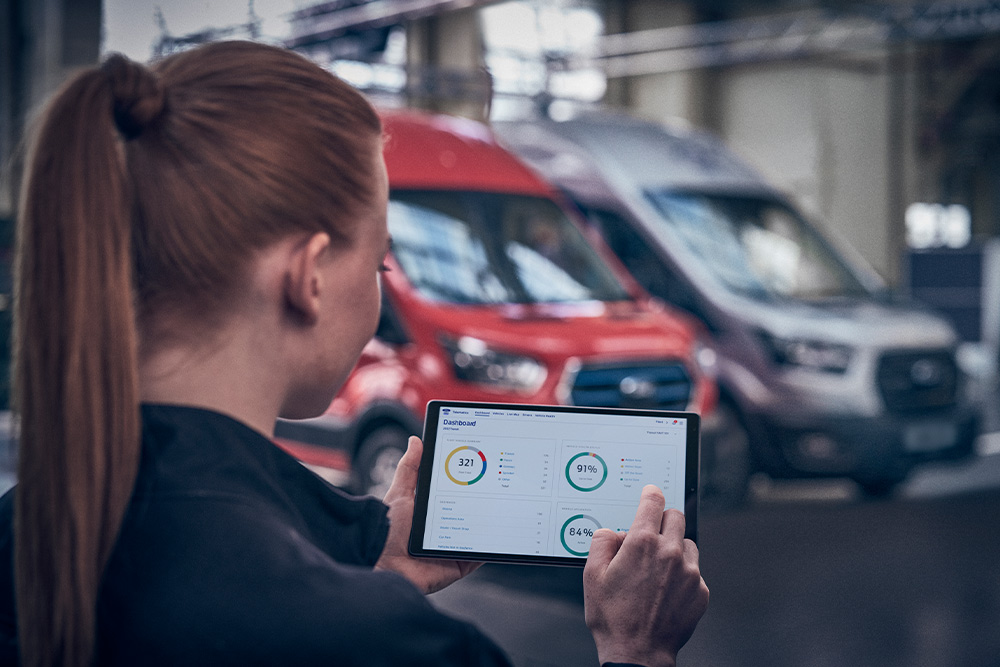 Gros plan d'une personne utilisant une tablette pour consulter les données de Ford Telematics Essentials.