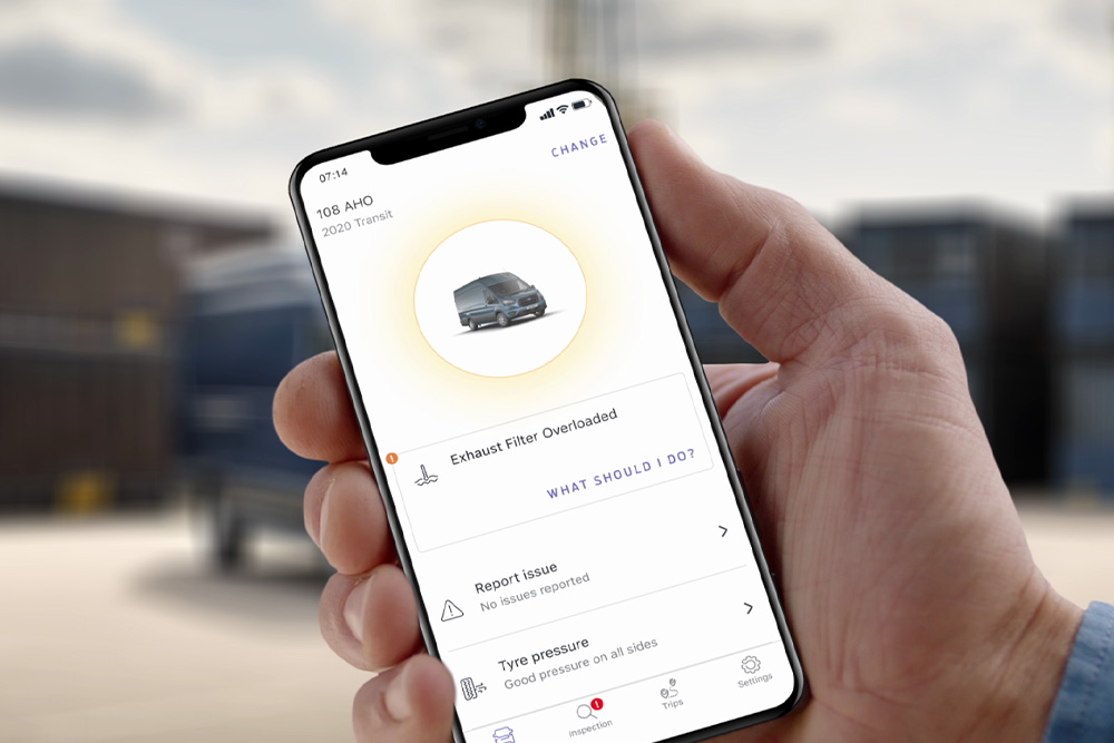 Une main tenant un appareil mobile, montrant l'application Ford Telematics Drive.